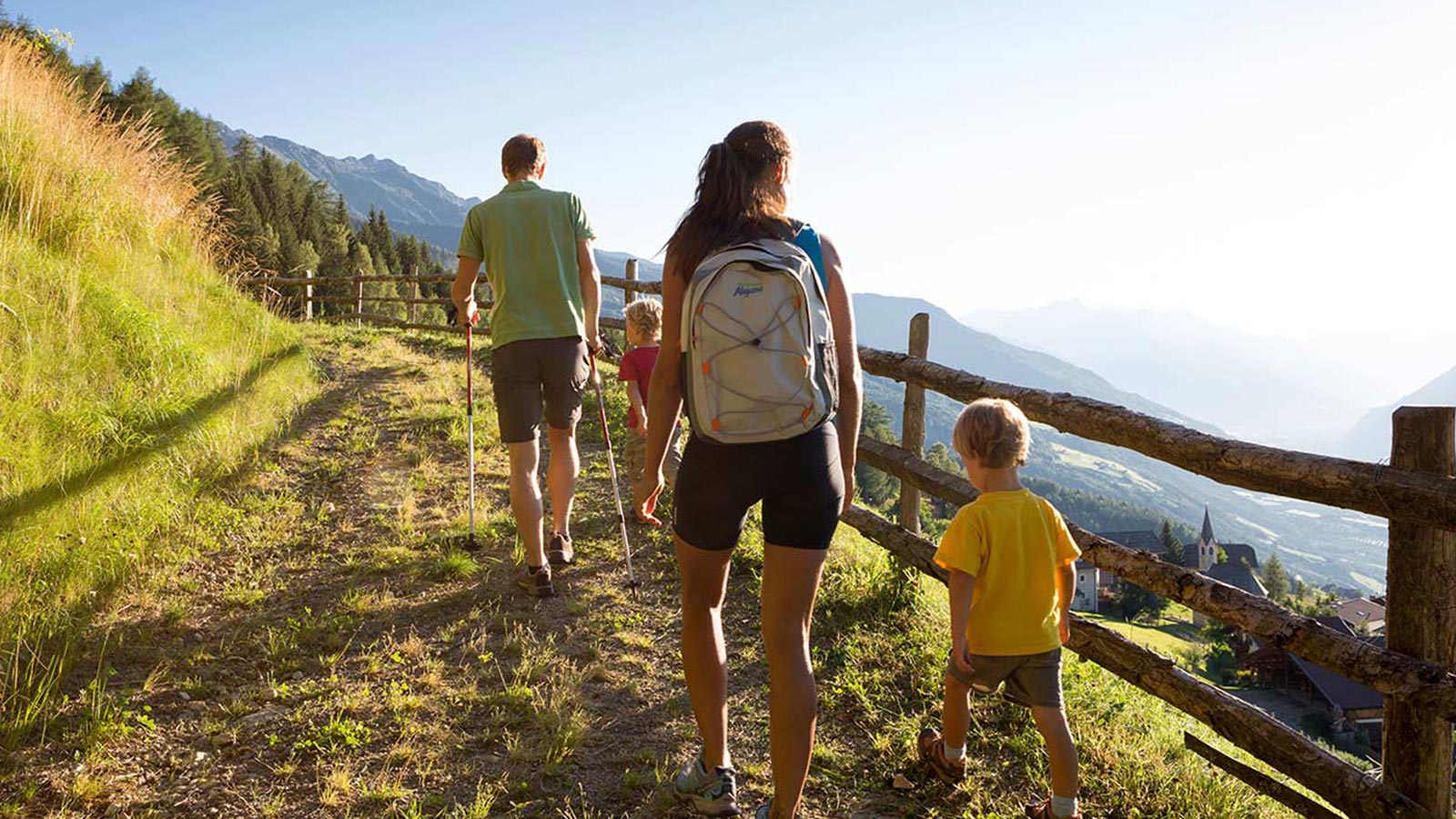 Eine Familie, die während eines Ferienaufenthaltes in unserer Residence in Südtirol für Kinder einen Weg entlang geht