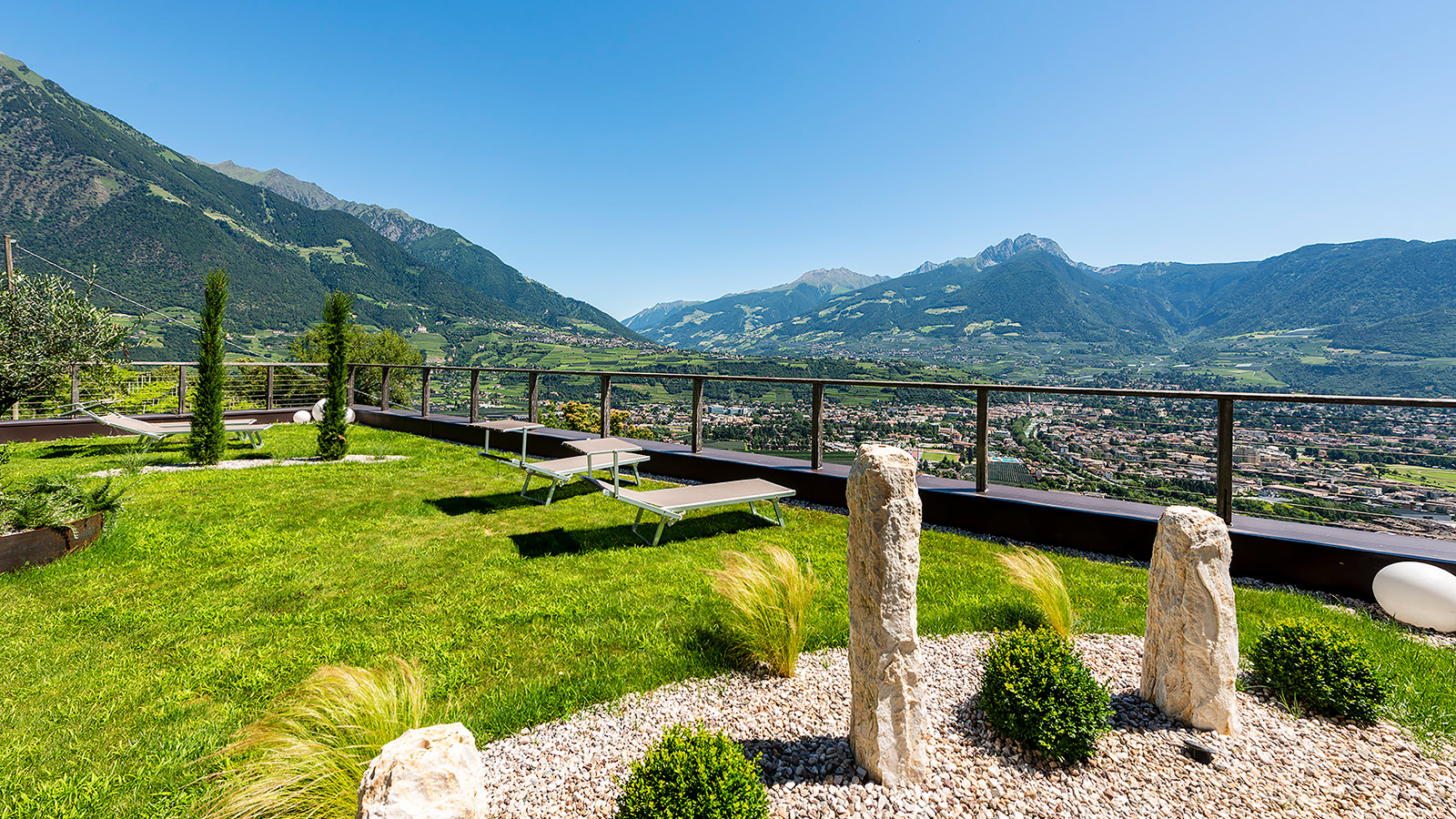 Eine Frau trinkt einen Aperitif auf der Terrasse der Residence Aqualis in Marling bei Meran